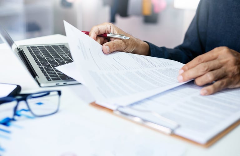 Asian businessman reviewing document reports at office workplace